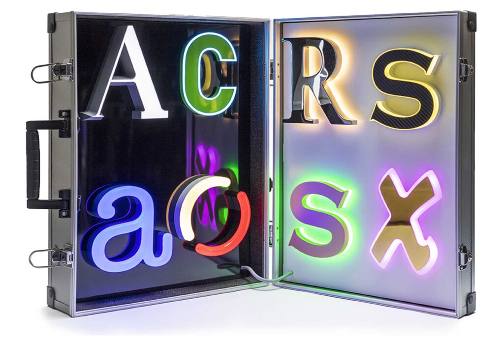 Ein Koffer mit verschiedenen Beispielen der Leuchttechnik, Buchstaben in verschiedenen Stilen und Farben